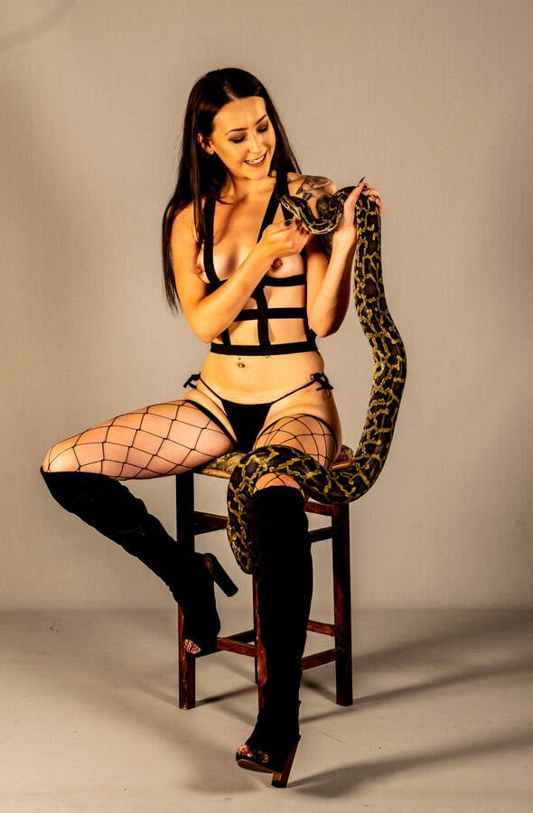 photographer Alan Tog lingerie modelling photo. a fairly new model posing in lingerie and knee high boots leonie is holding a snake called monty and yes it is a python.
